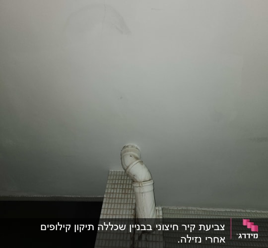 צינור לבן על קיר עם אריחים קטנים